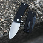 SHOOZIZ HAN306-BGS satin and BGB black PVD folding knives on stone, showcasing open and folded states with black G10 handles.