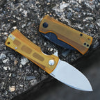 SHOOZIZ HAN306-JUS and JUB Ultem folding knives on stone, satin finish open and black PVD finish folded.