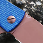 SHOOZIZ HAN306-LMRG blade close-up on stone, highlighting 14C28N steel and rose gold PVD finish, blue Micarta handle.