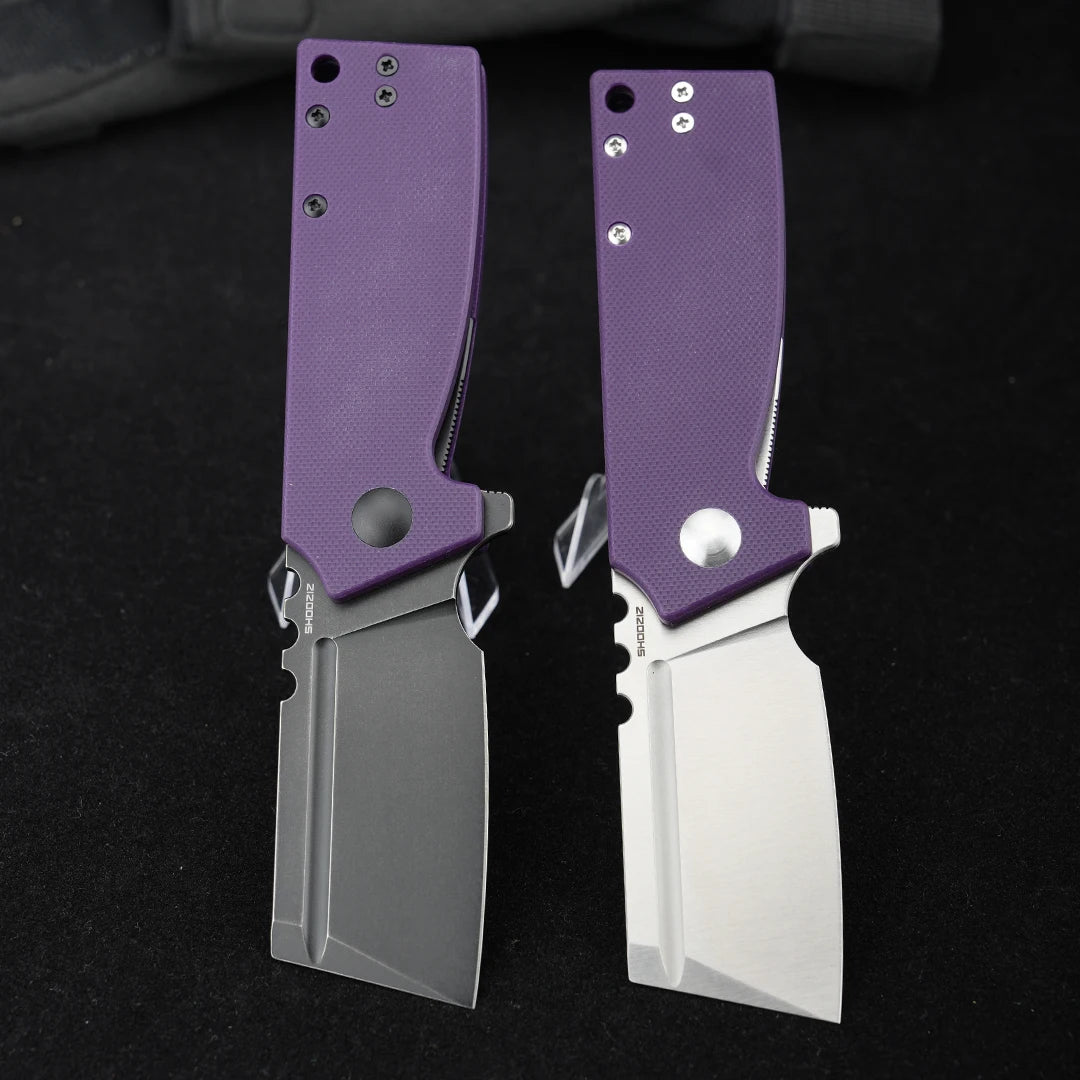 SHOOZIZ HAN307-PGB and HAN307-PGS folding knives open, comparing black PVD and satin D2 steel blades with purple G10 handles, black background.