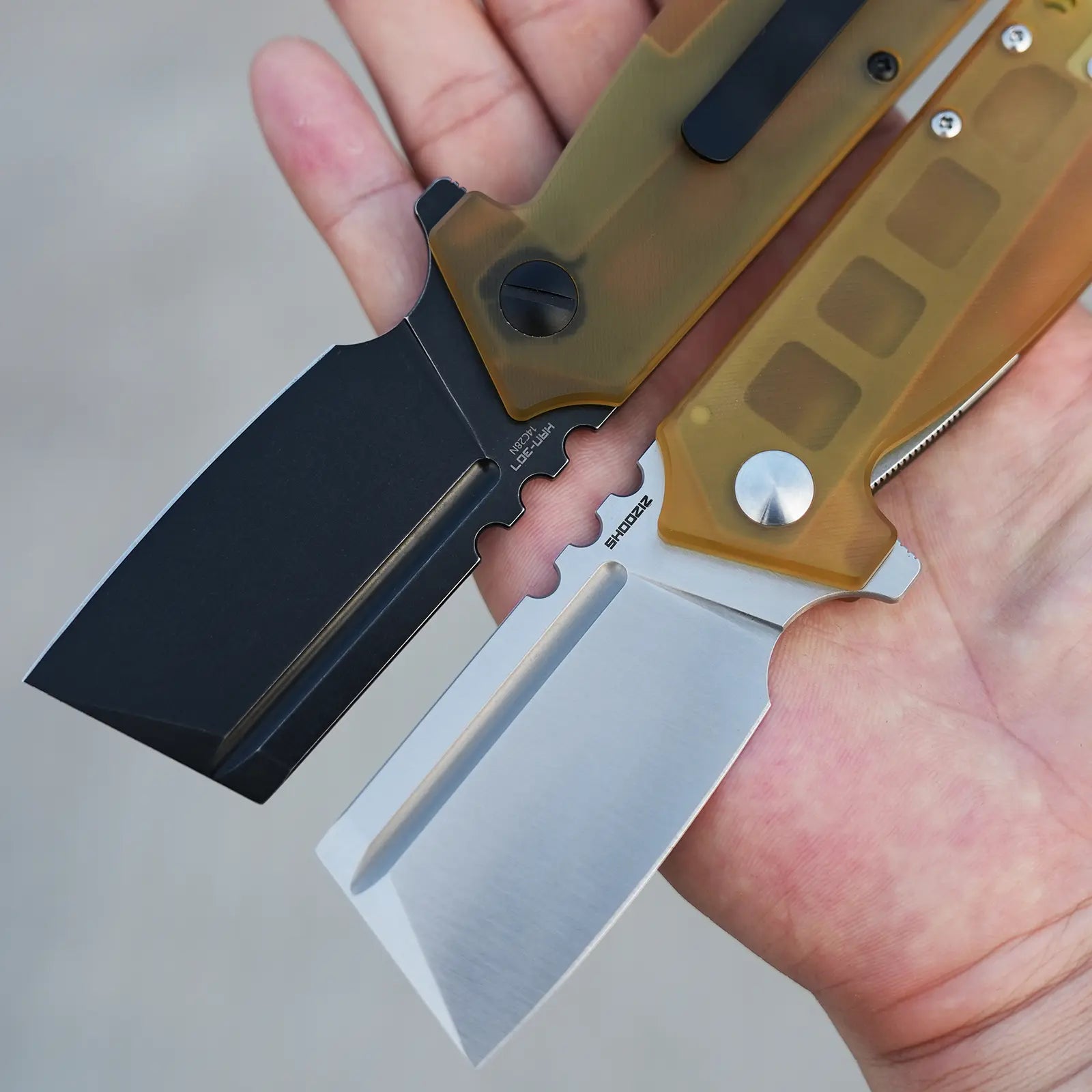 SHOOZIZ HAN307 Ultem handle folding knives in hand, comparison of satin finish 14C28N and black PVD models, liner lock, ceramic bearings.