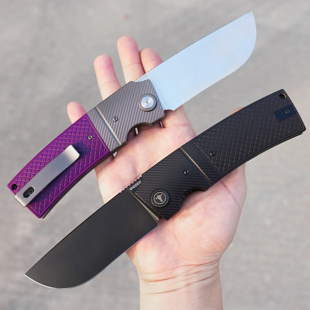 SHOOZIZ XUN122-PGS satin and XUN122-PGB black PVD held in hand, purple and black G10 handles with steel bolsters.